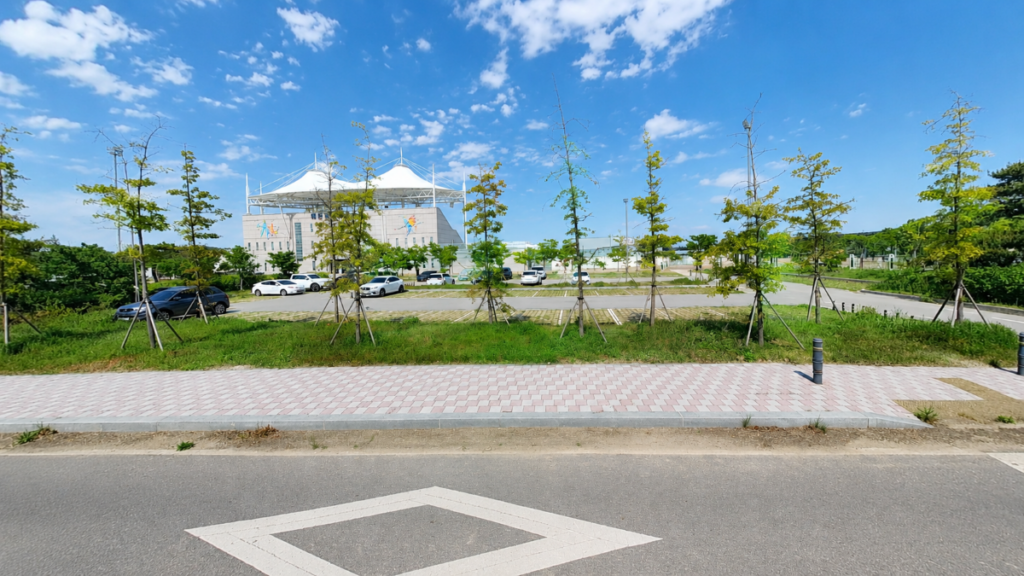 태안 간척지 주변 운동장과 도로, 주차장, 나무가 보이는 자연 여행 현장 사진